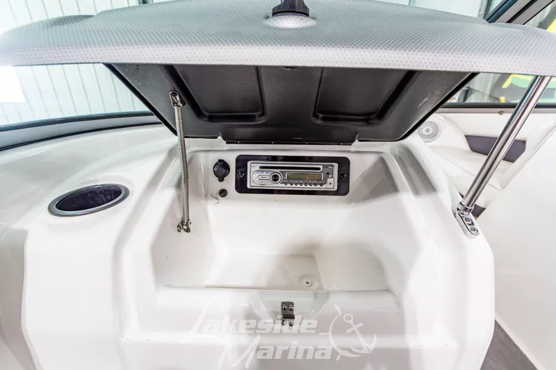 Slide: The Image of 2014 Yamaha SX190 boat dashboard with open storage compartment and stereo system. - 17
