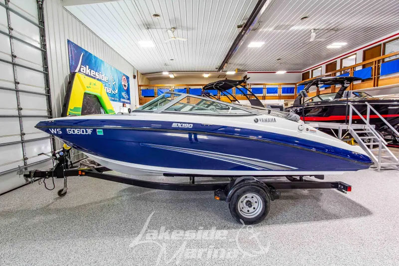 Slide: The Image of 2014 Yamaha Boats SX190 in showroom, blue and white, on trailer. - 2