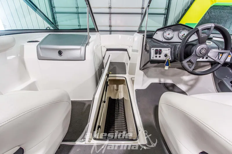 Slide: The Image of 2014 Yamaha Boats SX190 interior with steering wheel and storage compartment. - 20