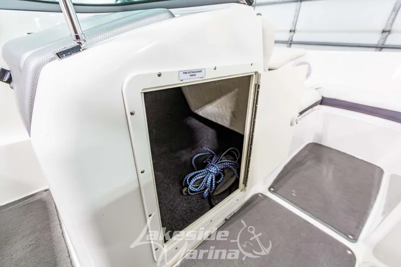 Slide: The Image of 2014 Yamaha Boats SX190 storage compartment with rope inside, featuring clean interior design. - 21