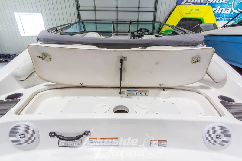 Slide: The Image of 2014 Yamaha Boats SX190 interior with open storage compartment in a marina setting. - 9