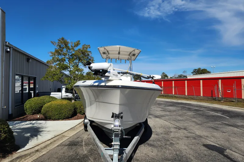 Slide: The Image of Steering console of 2021 Cobia 237 Center Console boat with controls and warning labels. - 11