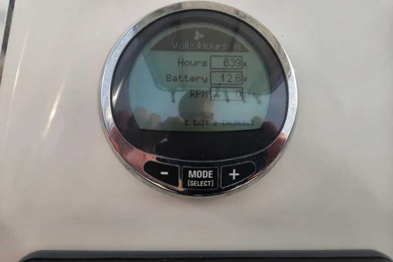 Slide: The Image of 2021 Cobia 237 Center Console boat battery compartment with wiring and metal handle. - 24