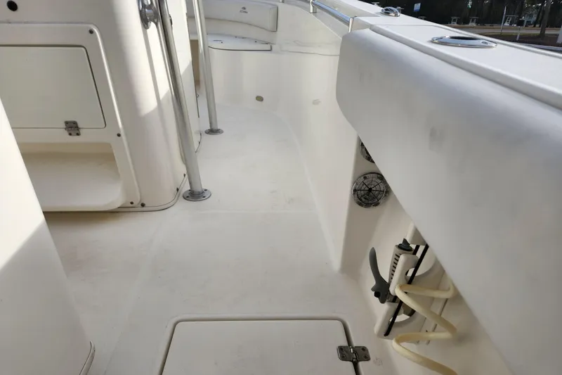 Slide: The Image of 2021 Cobia 237 Center Console boat interior, featuring clean white deck and storage compartments. - 7
