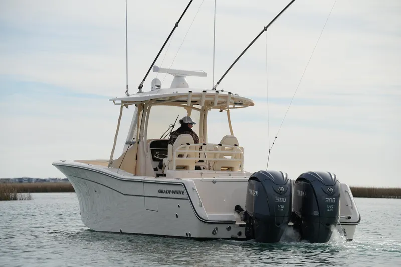 Slide: The Image of 2023 Grady-White Canyon 306 boat with dual Yamaha engines on calm water. - 10