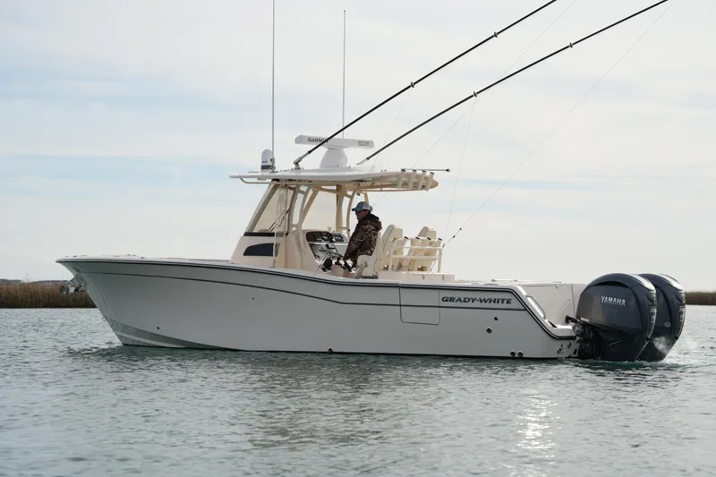 Slide: The Image of 2023 Grady-White Canyon 306 boat on water, side view, with fishing rods. - 13