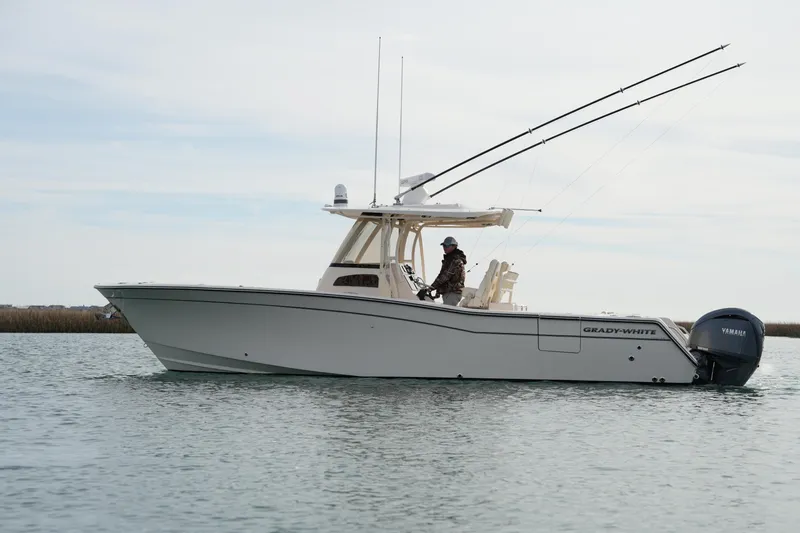 Slide: The Image of 2023 Grady-White Canyon 306 boat on water, side view, with fishing rods. - 14