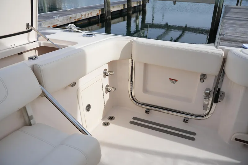 Slide: The Image of 2023 Grady-White Canyon 306 boat interior with white seating and dock view. - 17
