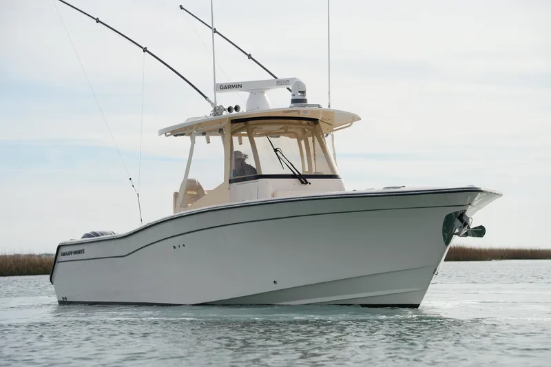 Slide: The Image of 2023 Grady-White Canyon 306 boat on calm water, showcasing sleek design and fishing equipment. - 3