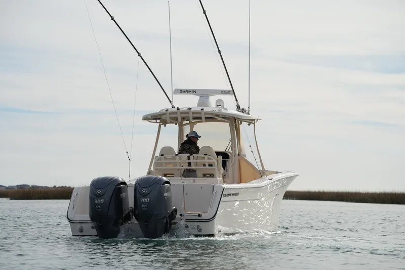 Slide: The Image of 2023 Grady-White Canyon 306 boat with dual engines on calm water. - 7