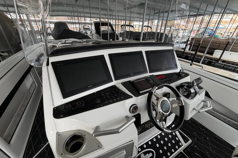 Slide: The Image of 2017 Cigarette 41' GTR boat dashboard with multiple screens and controls in a marina setting. - 9