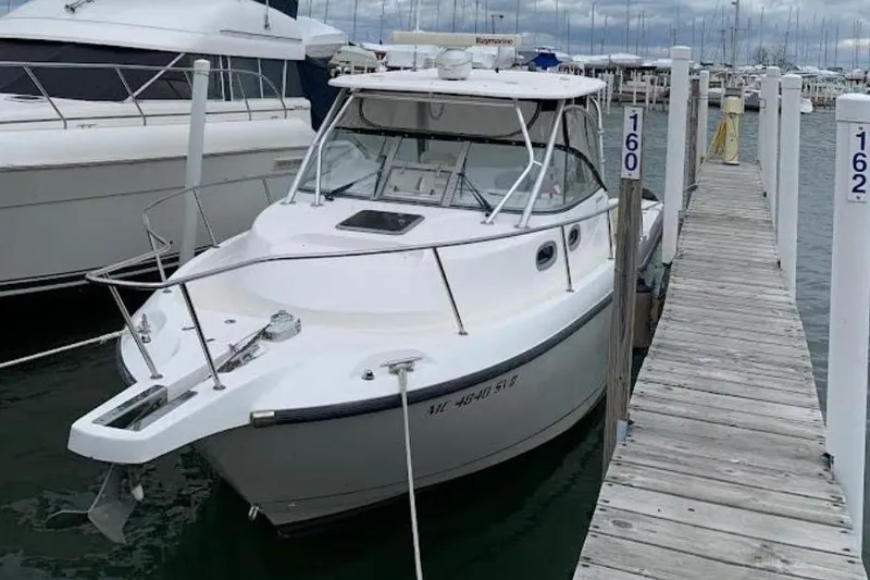 The Image of 2004 Boston Whaler 305 Conquest docked, calm waters. - 0