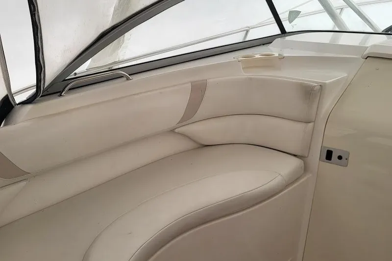 Slide: The Image of 2004 Boston Whaler 305 Conquest interior seating with beige upholstery and cup holder. - 11