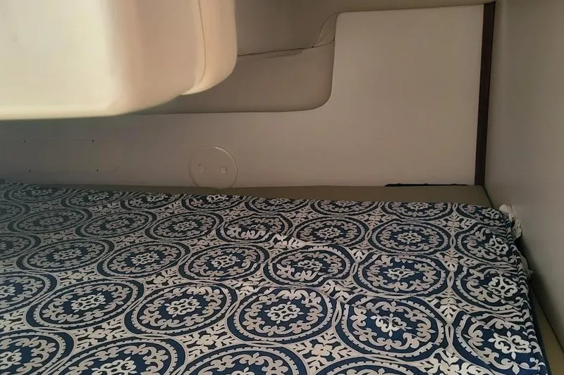 Slide: The Image of 2004 Boston Whaler 305 Conquest cabin interior with patterned bedding. - 15