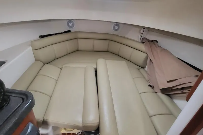 Slide: The Image of 2004 Boston Whaler 305 Conquest cabin interior with beige leather seating. - 16