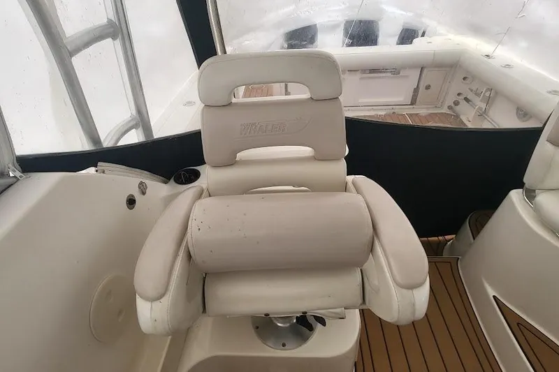 Slide: The Image of 2004 Boston Whaler 305 Conquest boat interior with cushioned seating and wooden flooring. - 17