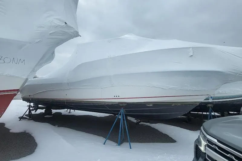 Slide: The Image of 2004 Boston Whaler 305 Conquest boat covered in protective wrap, stored on stands. - 3