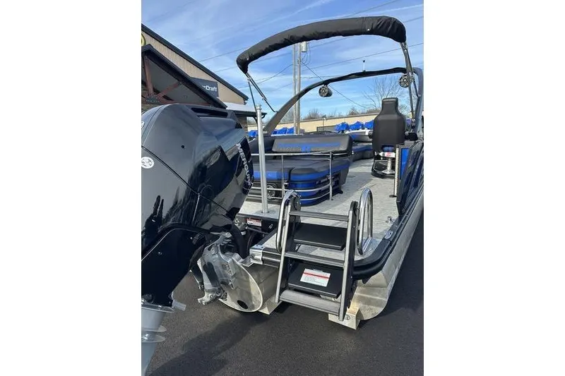 Slide: The Image of 2025 Bennington M Swingback 26 MSB pontoon boat with Mercury outboard engine and rear ladder. - 11