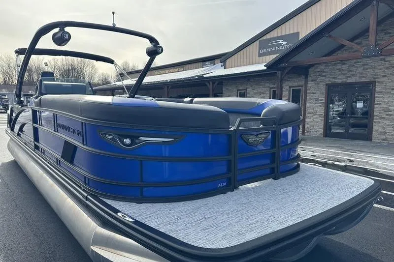Slide: The Image of 2025 Bennington M Swingback 26 MSB pontoon boat in front of dealership. - 5
