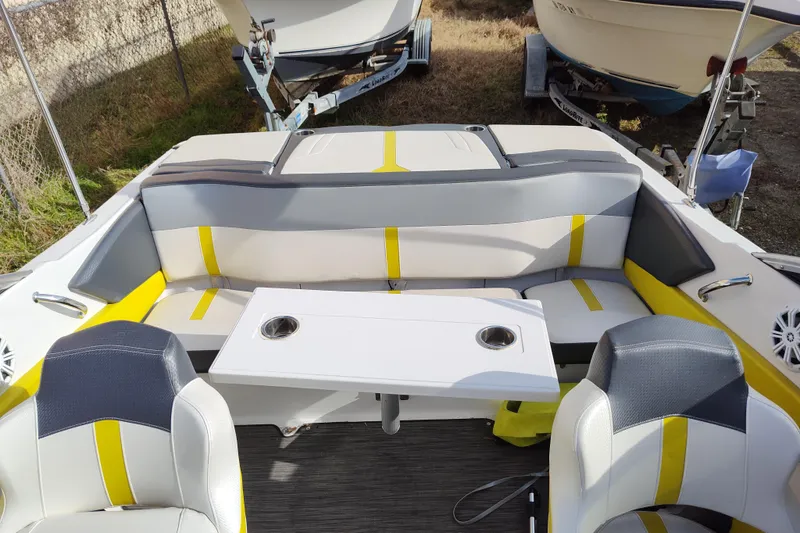 Slide: The Image of 2017 Four Winns 190 Horizon boat interior with seating and table, featuring yellow and gray accents. - 14