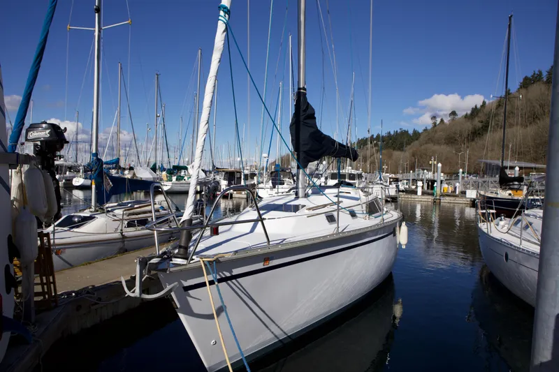 The Image of 1992 Hunter 33.5 sailboat docked in a marina under clear blue skies. - 0