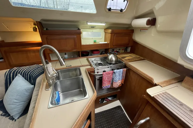 Slide: The Image of Cozy 1992 Hunter 33.5 sailboat kitchen with sink, stove, and wooden cabinetry. - 18