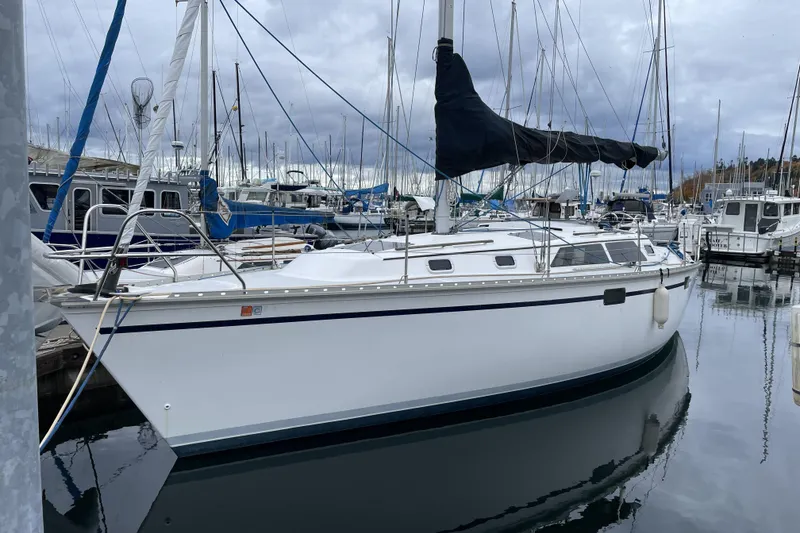 Slide: The Image of Sailboat Hunter 33.5, 1992 model, docked in a marina under cloudy skies. - 2