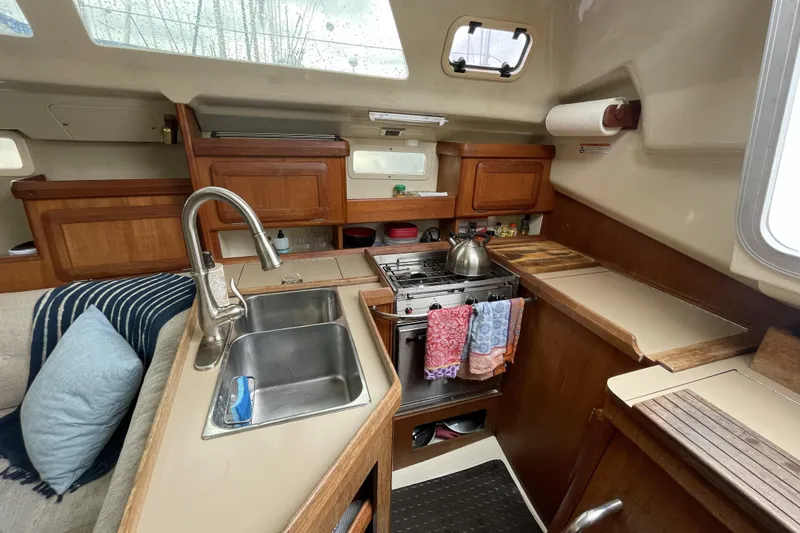 Slide: The Image of Interior of 1992 Hunter 33.5 sailboat kitchen with sink, stove, and wooden cabinetry. - 21