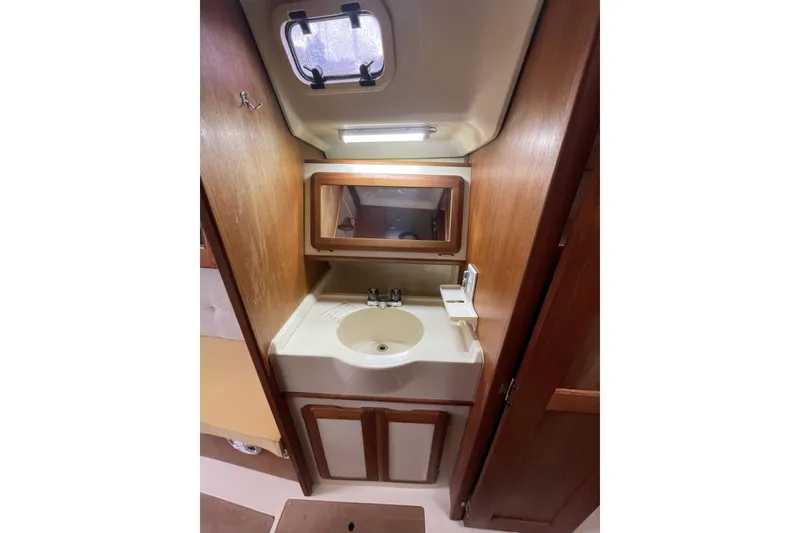 Slide: The Image of 1992 Hunter 33.5 yacht bathroom with sink, mirror, and wooden cabinetry. - 27