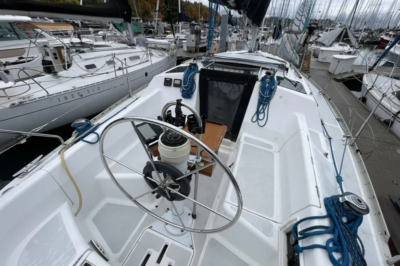 Slide: The Image of 1992 Hunter 33.5 sailboat cockpit with steering wheel, docked in marina. - 3