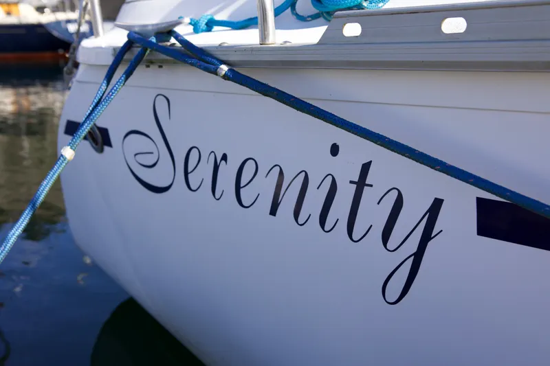Slide: The Image of 1992 Hunter 33.5 sailboat named "Serenity" docked with blue ropes. - 5