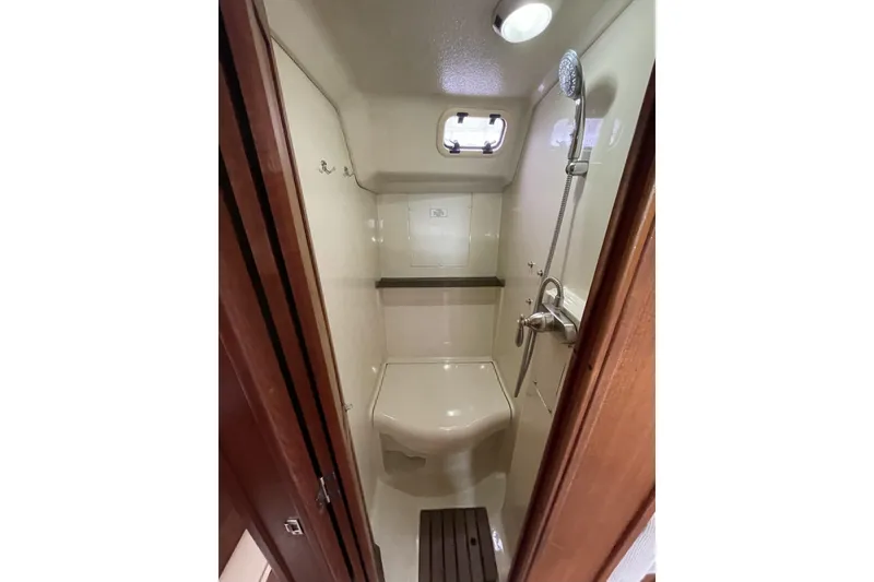 Slide: The Image of 1992 Hunter 33.5 yacht bathroom with shower, compact and well-lit interior. - 6