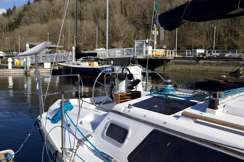 Slide: The Image of 1992 Hunter 33.5 sailboat docked at a marina with wooded background. - 9