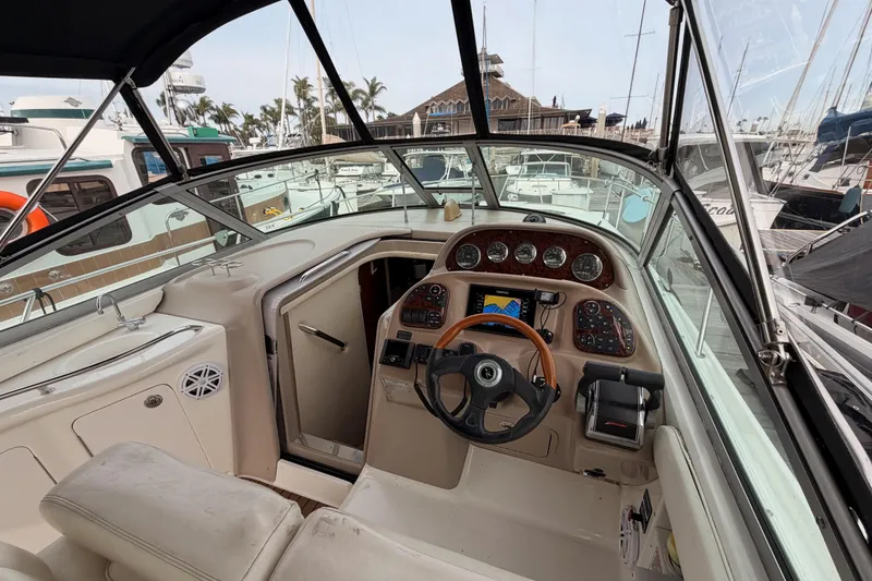 Slide: The Image of 2005 Sea Ray 300 Sundancer cockpit with steering wheel and control panel in marina. - 17
