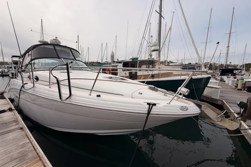 Slide: The Image of 2005 Sea Ray 300 Sundancer docked at marina, surrounded by sailboats. - 2