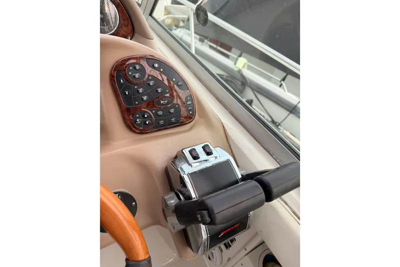 Slide: The Image of Control panel of a 2005 Sea Ray 300 Sundancer boat, featuring navigation and throttle controls. - 21