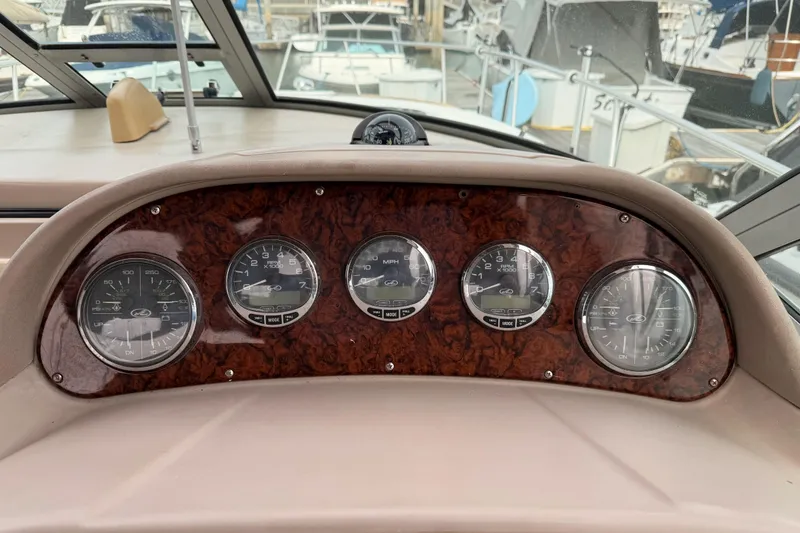 Slide: The Image of Dashboard of a 2005 Sea Ray 300 Sundancer boat with gauges and wood finish. - 22