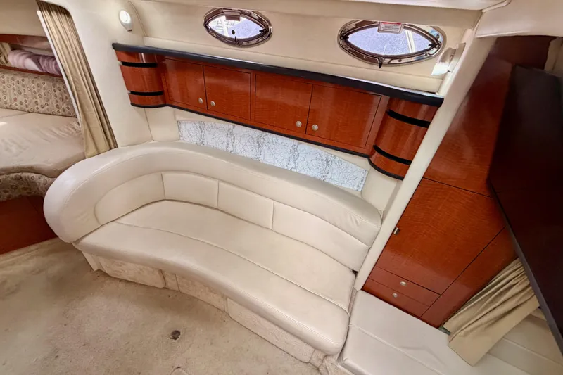 Slide: The Image of Luxurious interior of 2005 Sea Ray 300 Sundancer with curved leather seating and wooden cabinetry. - 25