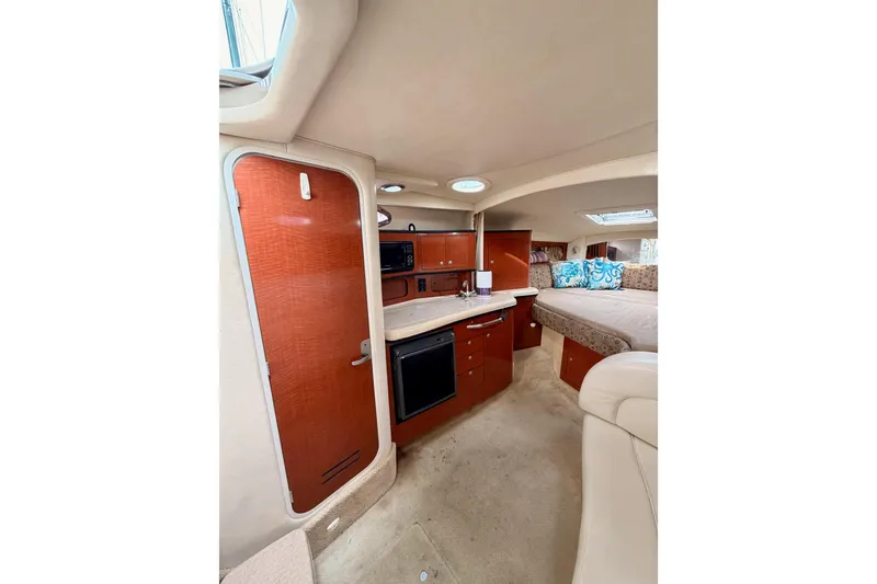 Slide: The Image of 2005 Sea Ray 300 Sundancer interior with kitchenette and cozy sleeping area. - 26