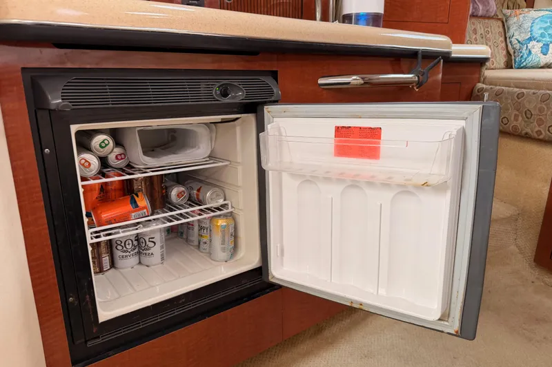 Slide: The Image of Mini fridge stocked with beverages inside a 2005 Sea Ray 300 Sundancer boat. - 29