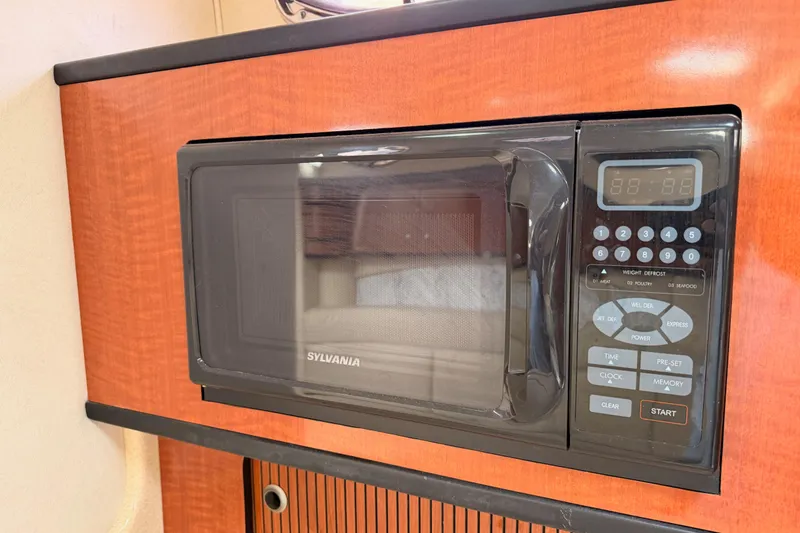 Slide: The Image of Microwave in 2005 Sea Ray 300 Sundancer boat interior, featuring wood paneling. - 31