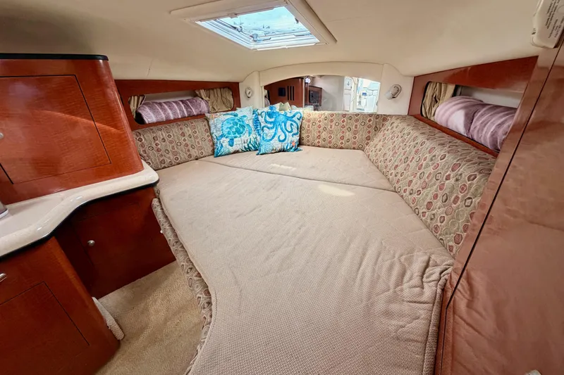 Slide: The Image of 2005 Sea Ray 300 Sundancer cabin with cozy bed, patterned cushions, and skylight. - 34