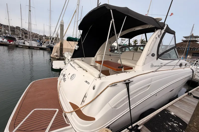 Slide: The Image of 2005 Sea Ray 300 Sundancer docked at marina, featuring sleek design and spacious deck. - 6