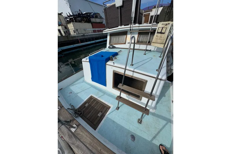 Slide: The Image of 1978 CHB 35 boat deck with ladder and blue towel, docked at marina. - 10