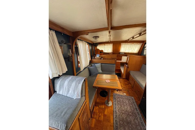 Slide: The Image of Interior of a 1978 CHB 35 boat with cozy seating and wooden furnishings. - 15