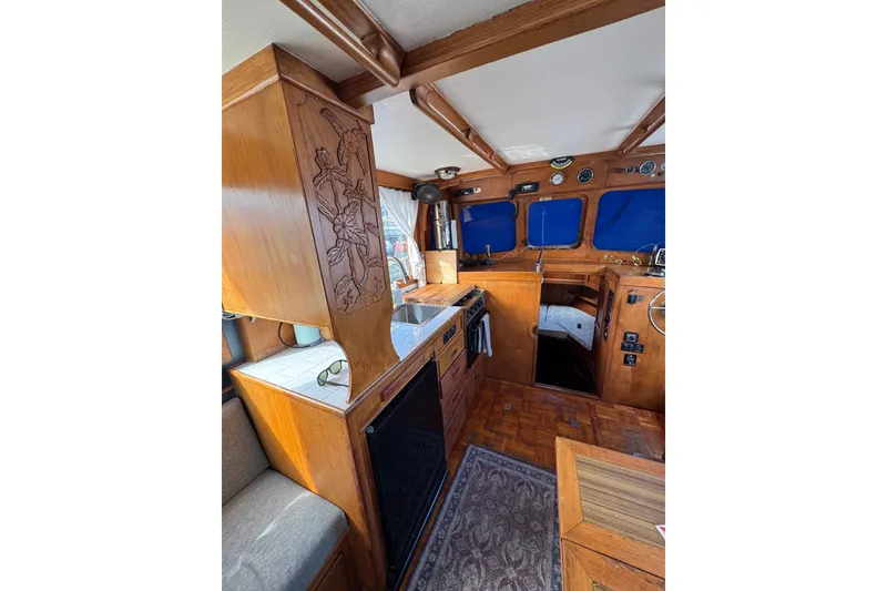 Slide: The Image of 1978 CHB 35 boat interior with wood finish, kitchen, and steering area. - 21