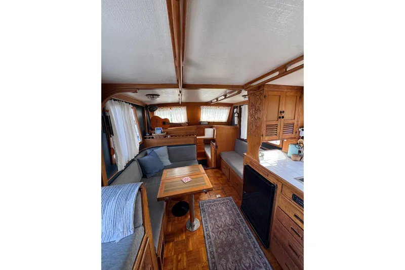 Slide: The Image of Interior of a 1978 CHB 35 boat with cozy wooden furnishings and seating area. - 22