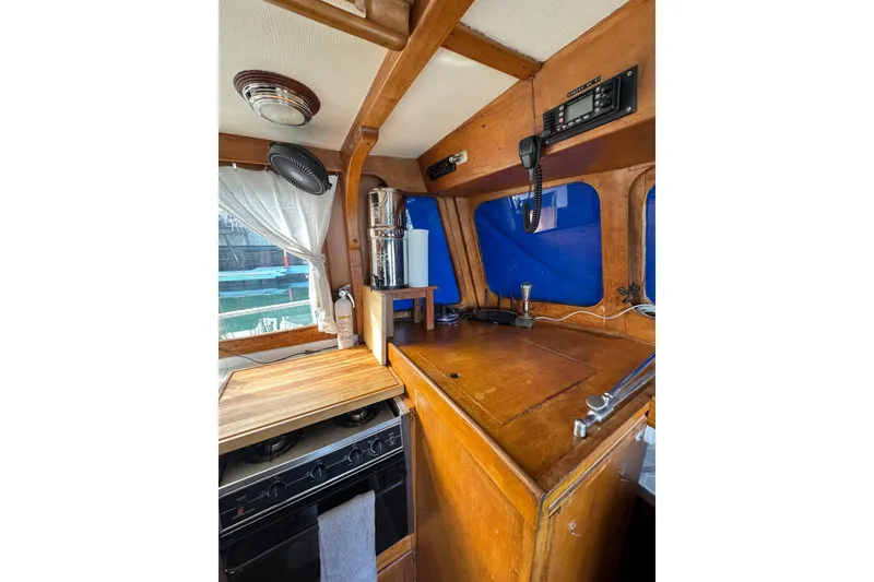 Slide: The Image of 1978 CHB 35 boat interior with wooden cabinetry, stove, and radio equipment. - 27