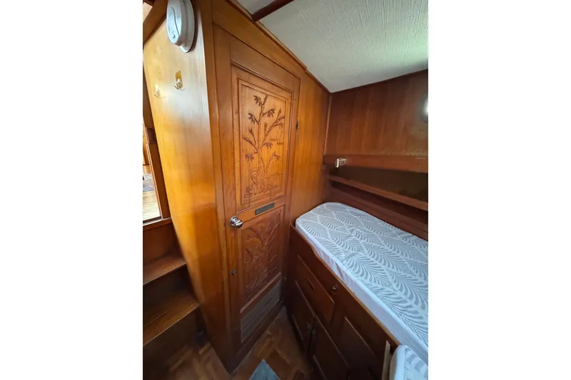 Slide: The Image of 1978 CHB 35 boat interior with carved wooden door and cozy sleeping area. - 28