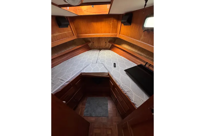 Slide: The Image of 1978 CHB 35 boat interior cabin with wooden finish and patterned bedding. - 31